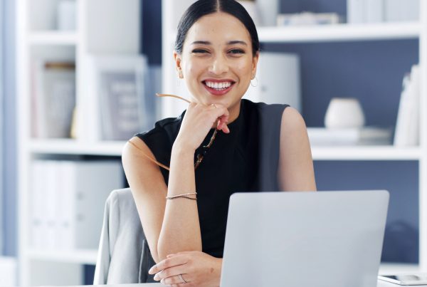 woman smiling in front of a computer